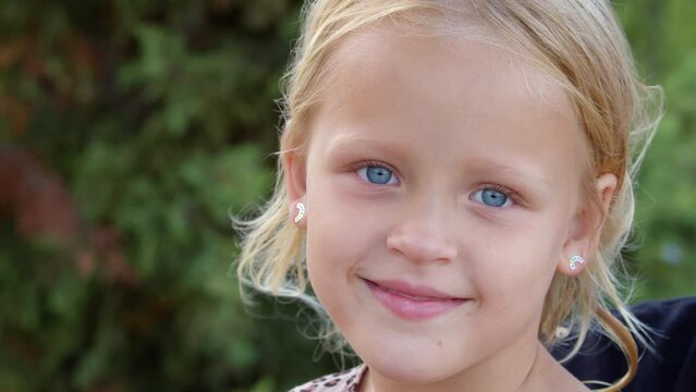 Cheerful little girl with big blue eyes outdoor