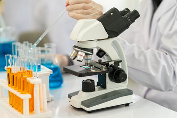 scientist doing research on plants holding a green solution in a test tube