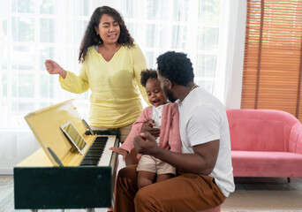 Shot of happy interracial family of mother father and their daughter inside modern apartment.