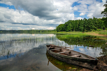 Old wooden boat on the forest lake in Aluksne. Aluksne Lake is a eleventh largest lake in Latvia and a place for rest and relaxation in Aluksne. Latvia - obrazy, fototapety, plakaty