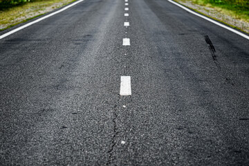 Close-up shot of asphalt road going into the distance