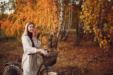 Happy active young woman ride bicycle in autumn park. Fall season,
