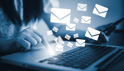 Businesswoman holding smartphone with communication icons, letter icon, email icons, and newsletter...