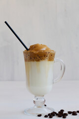 Dalgona coffee with whipped coffee or espresso on the white table. The Korean coffee drink on light background. Iced whipped dalgona coffee concept. copy space