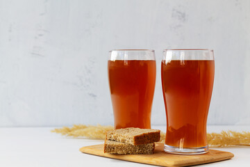 summer iced drinks. glass of beer and bread on the cutting board. two high Glasses of fresh kvass...