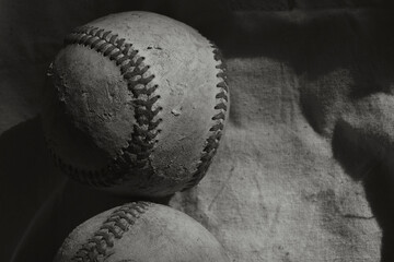 Old texture of used baseball closeup on linen background in black and white for sports art.