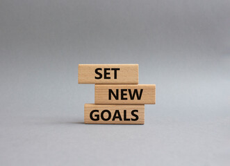 Set New Goals symbol. Wooden blocks with words Set New Goals. Beautiful grey background. Business...