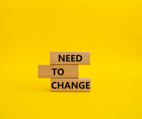 Need to change symbol. Concept words 'Need to change' on wooden blocks. Beautiful yellow background. Business and Need to change concept. Copy space.