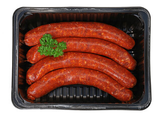 top view of raw spicy merguez sausages garnished with parsley in black plastic packaging