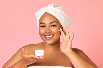 Black Female Applying Moisturizer Enjoying Facial Skincare Routine, Pink Background