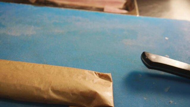 Chef rolling up white cod fish for baking in a Parchment Pape renvelope