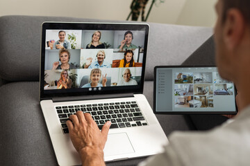 man working from home use Smart working and video conference online meeting with team using laptop and tablet online in video call for new projects