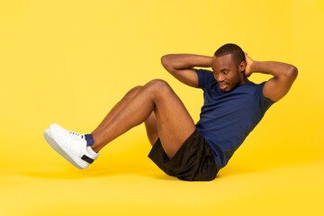 Black Fitness Guy Doing Sit Ups Exercise On Yellow Background - obrazy, fototapety, plakaty