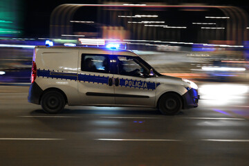 Fototapeta Radiowóz polskiej policji na sygnałach alarmowo szybko jedzie przez miasto na interwencję.  obraz