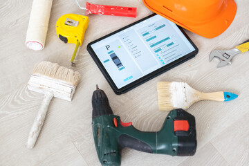 Different equipment tools of builder and tablet pc on wooden texture.