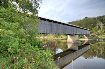 Fototapeta na wymiar covered bridge over water with reflection Lancaster New Hampshire