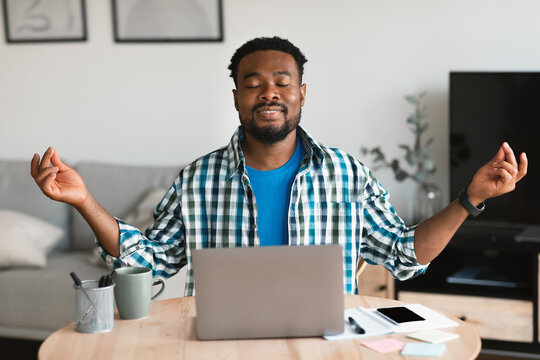 Relaxed African American Man Meditating At Laptop Sitting At Workplace