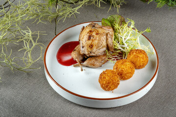 Grilled quail with cheese balls and herbs. Haute cuisine, beautiful display of dishes.