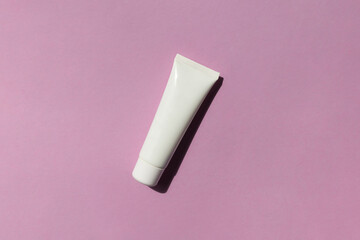 White plastic cosmetic tube on the velvet background top view	