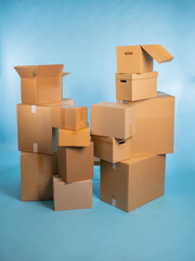 Carton boxes. Parcels are stacked on top of each other. Boxes for packing orders from online store. Many parcels of different sizes on turquoise. Open and closed boxes without inscriptions