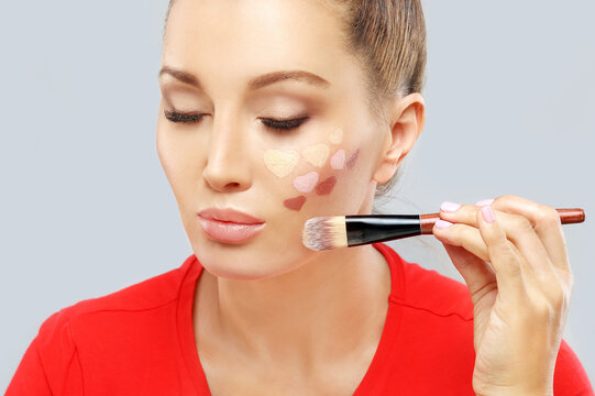 Portrait of beautiful woman holding make-up brushes.Putting makeup .Contouring.Make up woman face. Contour and highlight makeup.