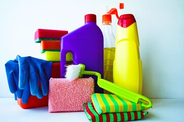 On a blue background on the table are detergents and disinfectants for cleaning houses and premises.  Protective equipment, gloves, cleaning agent bottles.  The concept of purity and freshness.  