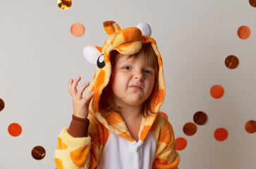 Emotional little girl in giraffe costume on white background. Halloween party celebration