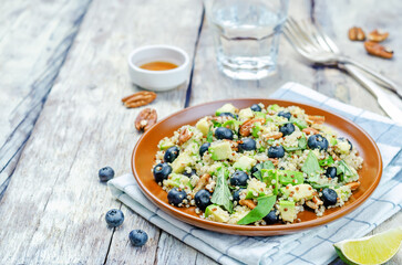 Quinoa avocado blueberry pecan salad with maple syrup lime dressing in a plate