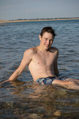 A 17 Year Old Teenage Boy Sitting On A Beach
