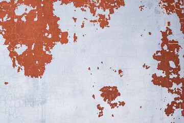 A solid texture of a white wall with peeling red plaster. Peeled paint wall background