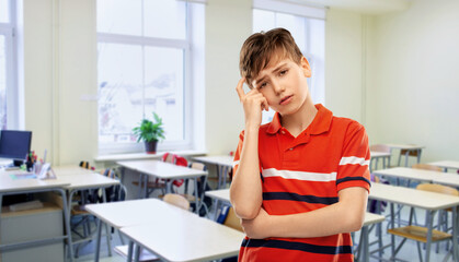 education, school and people concept - portrait of sad thinking boy in red polo t-shirt over...