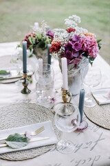 Modern wedding table decorated with plates, cutlery and flowers