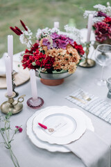 Modern wedding table decorated with plates, cutlery and flowers