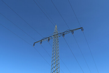 View of very large electricity pylons with high voltage cables from a moving car.