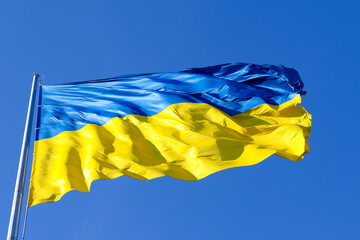 Ukrainian flag against clear blue sky. National holiday. Independence Day of Ukraine. Colors of freedom. Selective focus