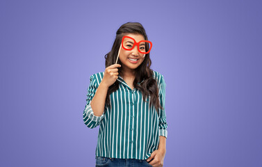 party props, photo booth and people concept - happy woman with big glasses over violet background
