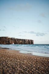 Shot of a beach with a cliff which waves are crashing on. Algarve, Portugal.