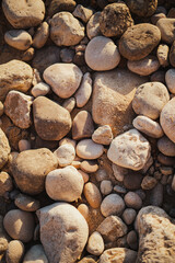 Zenith shot of beach stones on the sand with sun rays during sunset in Algarve, Portugal