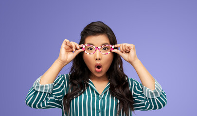 party props, photo booth and people concept - surprised woman with glasses over violet background