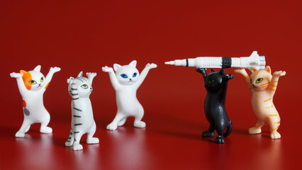 Toy dancing kittens from a meme and a rocket with a warhead on a red background. Anti-war...