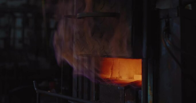 gas furnace in forge workshop, closeup view, flame from oven, metal billets are heating, 4K, Prores