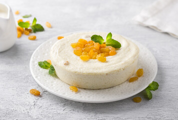 Delicate steam Cottage cheese casserole with raisins decorated with mint on a light gray background. Delicious homemade vegetarian food