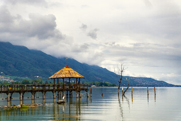 beautiful pier on a lake with mountains on background
