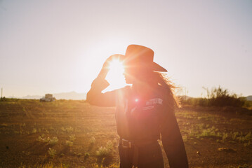 Woman in western fashion and cowboy hat with sun flare