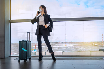 Girl at the airport window waits for a flight