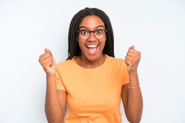 black young adult woman feeling shocked, excited and happy, laughing and celebrating success,...