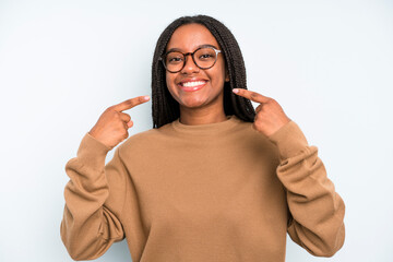 black young adult woman smiling confidently pointing to own broad smile, positive, relaxed,...