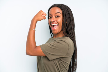 black young adult woman feeling happy, satisfied and powerful, flexing fit and muscular biceps,...