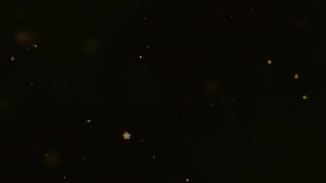 An explosion of bright yellow particles in a slow motion on a black background.