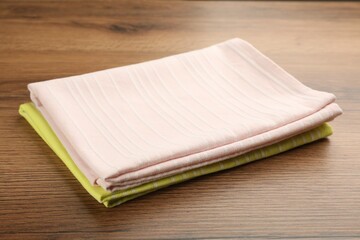 Pink and yellow kitchen towels on wooden table